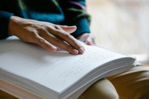 une main qui lit un livre braille