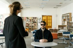 un homme aveugle écoutant le cour d'une formatrice.